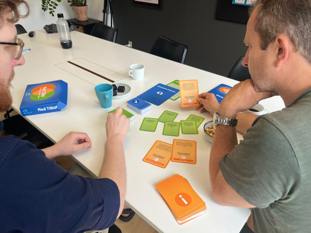 To deltagere diskuterer en dilemmakort i Copenhagen Game Labs gamification-læringsspil
